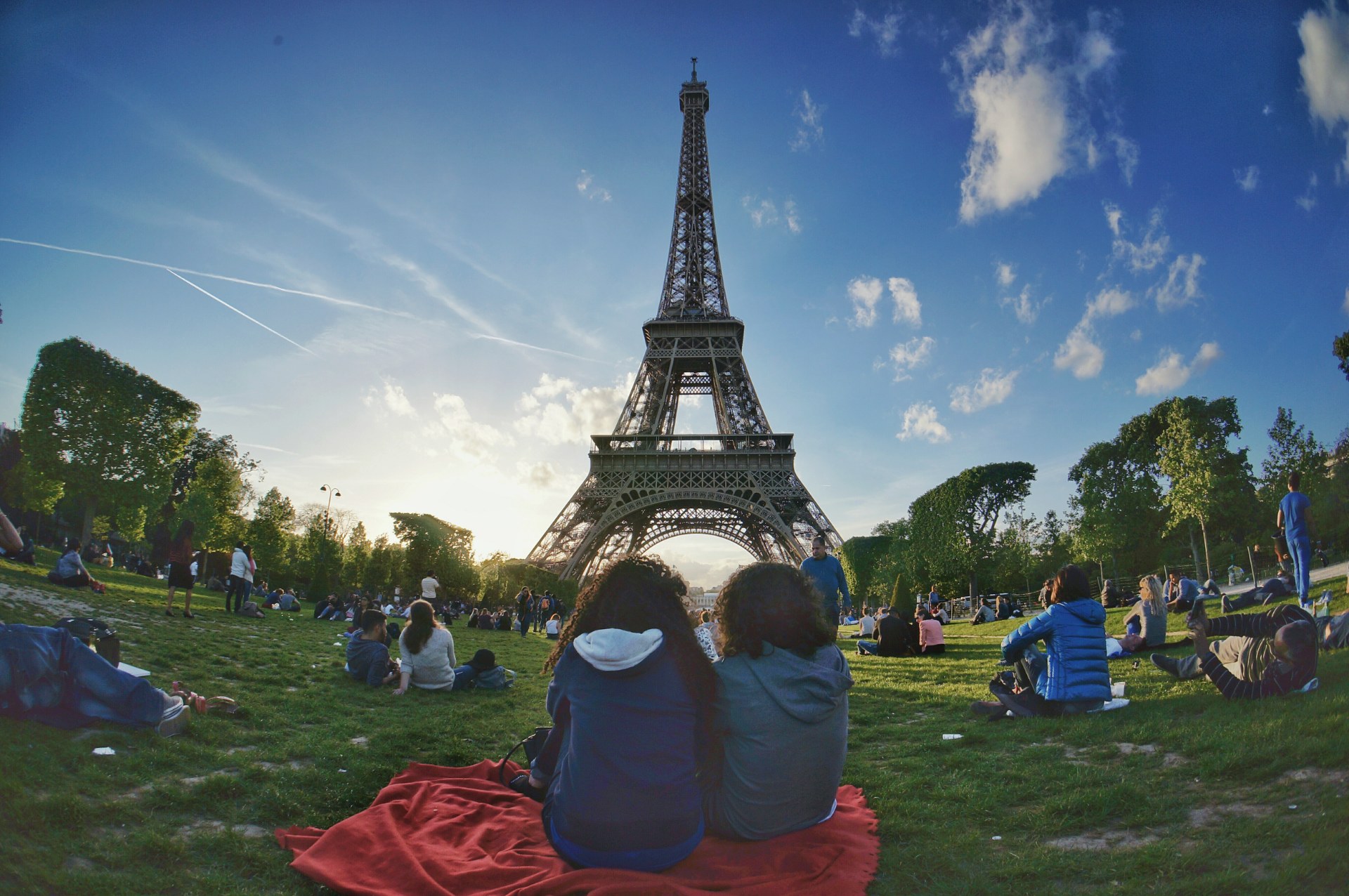 Young people relaxing on the grass of the Champ de Mars with the Eiffel Tower in the background